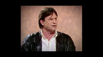 Movie still from “He Dreams of Giants” (2019), directed by Louis Pepe – A person wearing a leather jacket; Close Up shot, High angle