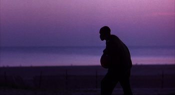 Movie still from “He Got Game” (1998), directed by Spike Lee – A man holding a basketball in his hand; Wide shot, Low angle