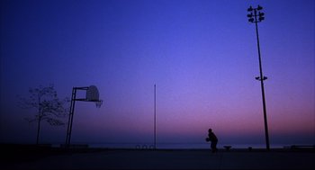 Movie still from “He Got Game” (1998), directed by Spike Lee – A person is playing basketball on the beach at dusk; Extreme Wide shot, Low angle