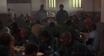 Movie still from “He Got Game” (1998), directed by Spike Lee – A group of men sitting at a table in a room; Wide shot, High angle