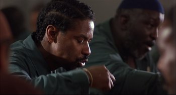 Movie still from “He Got Game” (1998), directed by Spike Lee – A man sitting in front of another man looking at his watch; Close Up shot, Low angle