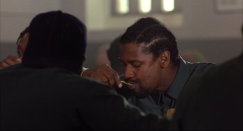 Movie still from “He Got Game” (1998), directed by Spike Lee – A man is eating something while sitting down; Close Up shot, Over the shoulder angle