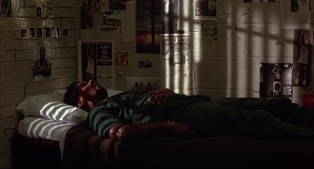 Movie still from “He Got Game” (1998), directed by Spike Lee – A man laying on a couch in a room; Wide shot, High angle