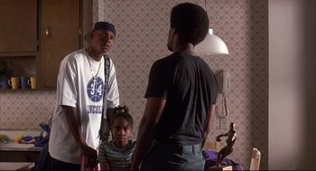 Movie still from “He Got Game” (1998), directed by Spike Lee – A group of people standing around in a room; Medium shot, Over the shoulder angle