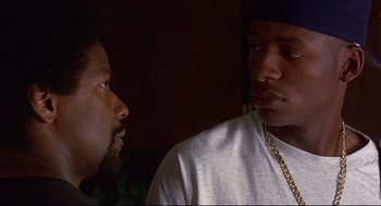 Movie still from “He Got Game” (1998), directed by Spike Lee – Two men are looking at each other in the dark; Close Up shot, Over the shoulder angle