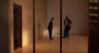 Movie still from “He Got Game” (1998), directed by Spike Lee – Two men in suits are standing in a room; Extreme Wide shot, High angle