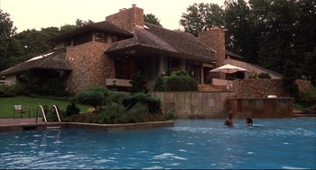 Movie still from “He Got Game” (1998), directed by Spike Lee – A man swimming in a pool near a house; Extreme Wide shot, High angle