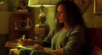 Movie still from “He Got Game” (1998), directed by Spike Lee – A woman sitting in a chair looking down at her cell phone; Medium shot, High angle