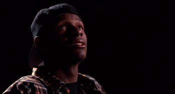 Movie still from “He Got Game” (1998), directed by Spike Lee – A man with a hat is looking up at the sky; Close Up shot, Low angle