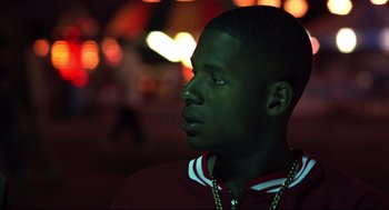 Movie still from “He Got Game” (1998), directed by Spike Lee – A young man is looking into the distance at night; Close Up shot, Over the shoulder angle