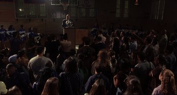 Movie still from “He Got Game” (1998), directed by Spike Lee – A crowd of people gathered in a gymnasium to hear a speaker; Extreme Wide shot, High angle