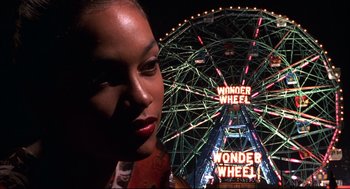 Movie still from “He Got Game” (1998), directed by Spike Lee – A woman standing in front of a ferris wheel at night; Close Up shot, Low angle