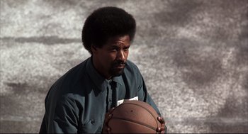 Movie still from “He Got Game” (1998), directed by Spike Lee – A man holding a basketball in his hands; Close Up shot, Low angle