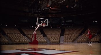 Movie still from “He Got Game” (1998), directed by Spike Lee – A basketball hoop in the middle of an empty arena; Extreme Wide shot, High angle
