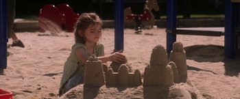 Movie still from “He's Just Not That Into You” (2009), directed by Ken Kwapis – A little girl is playing with sand on the beach; Medium shot, High angle