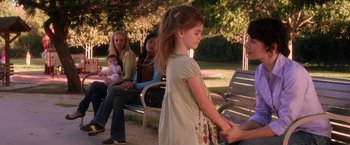 Movie still from “He's Just Not That Into You” (2009), directed by Ken Kwapis – A little girl is holding her mother's hand while sitting on a park bench; Medium shot, Over the shoulder angle