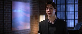 Movie still from “He's Just Not That Into You” (2009), directed by Ken Kwapis – A man in a suit and tie holding a bottle of wine; Close Up shot, Over the shoulder angle