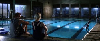 Movie still from “He's Just Not That Into You” (2009), directed by Ken Kwapis – A woman sitting in front of an indoor swimming pool; Wide shot, Over the shoulder angle
