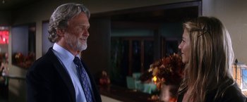 Movie still from “He's Just Not That Into You” (2009), directed by Ken Kwapis – An older man standing in front of a table with flowers; Medium shot, Over the shoulder angle