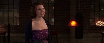 Movie still from “He's Just Not That Into You” (2009), directed by Ken Kwapis – A woman in a purple dress smiling for the camera; Medium shot, Over the shoulder angle