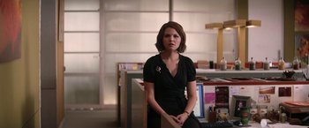 Movie still from “He's Just Not That Into You” (2009), directed by Ken Kwapis – A woman in a black dress sitting in an office; Medium shot, Over the shoulder angle