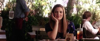 Movie still from “He's Just Not That Into You” (2009), directed by Ken Kwapis – A beautiful woman sitting at a table with her hand on her face; Medium shot, Over the shoulder angle