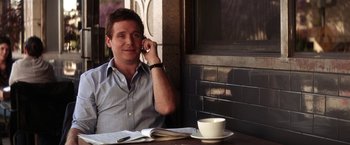 Movie still from “He's Just Not That Into You” (2009), directed by Ken Kwapis – A man sitting at a table talking on a cell phone; Medium shot, High angle