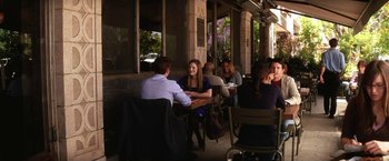 Movie still from “He's Just Not That Into You” (2009), directed by Ken Kwapis – A group of people sitting at a table outside of a building; Wide shot, Over the shoulder angle