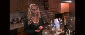 Movie still from “He's Just Not That Into You” (2009), directed by Ken Kwapis – A woman standing in a kitchen next to a counter; Medium shot, Over the shoulder angle