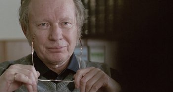 Movie still from “Head-On” (2004), directed by Fatih Akin – An older man holding a pair of eyeglasses in his hand; Close Up shot, Over the shoulder angle