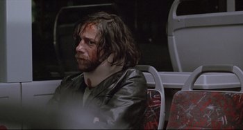 Movie still from “Head-On” (2004), directed by Fatih Akin – A man sitting on a bus with blood all over his face; Close Up shot, Low angle