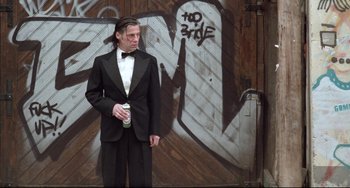 Movie still from “Head-On” (2004), directed by Fatih Akin – A man in a tuxedo standing in front of a graffiti wall; Medium shot, Low angle