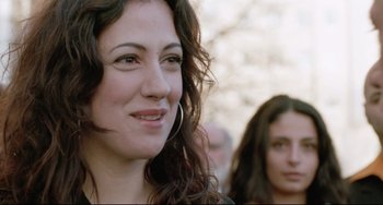Movie still from “Head-On” (2004), directed by Fatih Akin – A woman with long dark curly hair smiles at the camera; Close Up shot, Over the shoulder angle