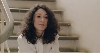 Movie still from “Head-On” (2004), directed by Fatih Akin – A woman with long black curly hair sitting in front of stairs; Close Up shot, Low angle