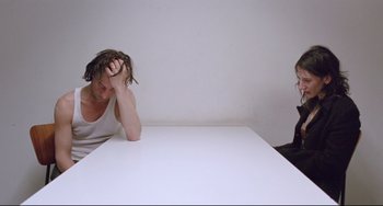 Movie still from “Head-On” (2004), directed by Fatih Akin – A man sitting at a table with his head resting on his hands; Medium shot, High angle