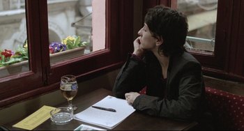 Movie still from “Head-On” (2004), directed by Fatih Akin – A woman sitting at a table with a glass of wine; Medium shot, Over the shoulder angle