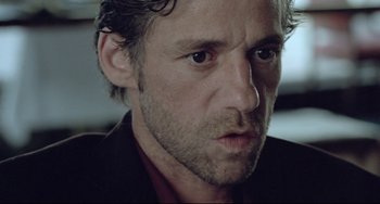 Movie still from “Head-On” (2004), directed by Fatih Akin – A person wearing a suit and tie; Close Up shot, Low angle