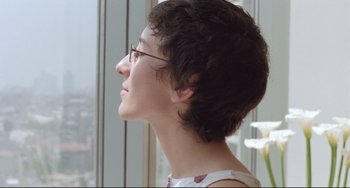 Movie still from “Head-On” (2004), directed by Fatih Akin – A woman wearing glasses looking out of a window; Close Up shot, Low angle