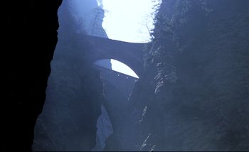 Movie still from “Heart of Glass” (1976), directed by Werner Herzog – A view of a bridge in the middle of a canyon; Extreme Wide shot, High angle