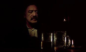 Movie still from “Heart of Glass” (1976), directed by Werner Herzog – A man sitting in front of two glasses of beer; Close Up shot, Low angle