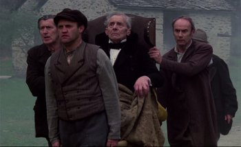 Movie still from “Heart of Glass” (1976), directed by Werner Herzog – A group of men standing next to each other; Medium shot, Low angle