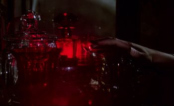 Movie still from “Heart of Glass” (1976), directed by Werner Herzog – A person holding a wine glass in a dark room; Extreme Close Up shot, High angle