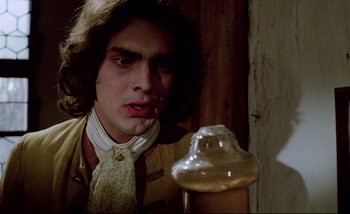 Movie still from “Heart of Glass” (1976), directed by Werner Herzog – A young man looking at a jar in front of him; Close Up shot, Low angle