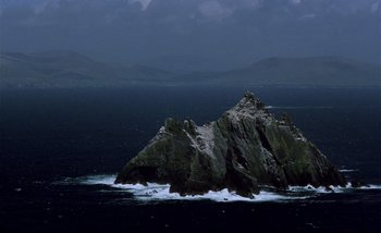 Movie still from “Heart of Glass” (1976), directed by Werner Herzog – A large rock in the middle of a body of water; Extreme Wide shot, High angle