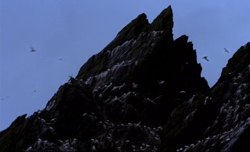 Movie still from “Heart of Glass” (1976), directed by Werner Herzog – A flock of birds sitting on top of a mountain; Extreme Wide shot, Low angle