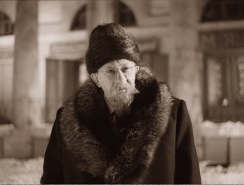Movie still from “Heart of a Dog” (1988), directed by Vladimir Bortko – An old man wearing a hat and a fur coat; Close Up shot, Low angle