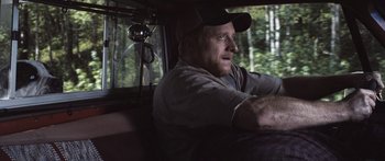 Movie still from “Tucker and Dale vs Evil” (2010), directed by Eli Craig – A man sitting in the driver's seat of a car; Medium shot, Over the shoulder angle