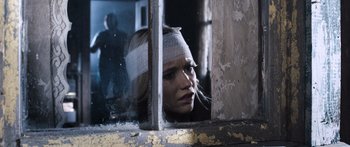 Movie still from “Tucker and Dale vs Evil” (2010), directed by Eli Craig – A woman with a bandage on her head looking out of a window; Close Up shot, Over the shoulder angle