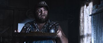 Movie still from “Tucker and Dale vs Evil” (2010), directed by Eli Craig – A man with a beard holding a tray of food in a dark room; Close Up shot, Low angle