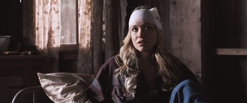 Movie still from “Tucker and Dale vs Evil” (2010), directed by Eli Craig – A woman wearing a head band sitting on a couch; Medium shot, Over the shoulder angle